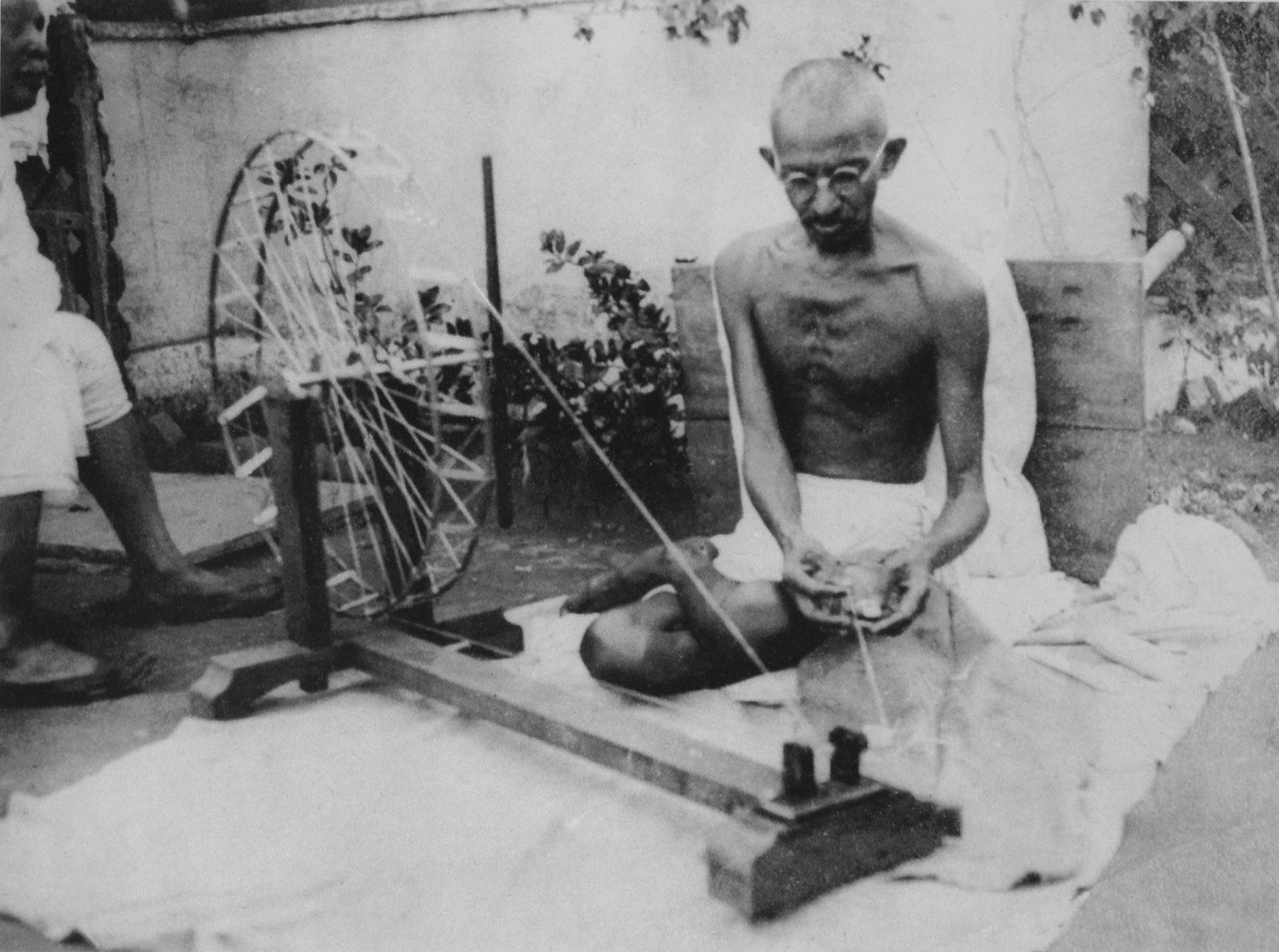 Mahatma Gandhi spinning thread at a spinning wheel